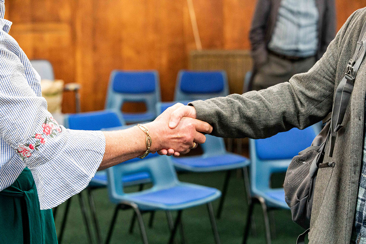 Two people shaking hands after a meeting.